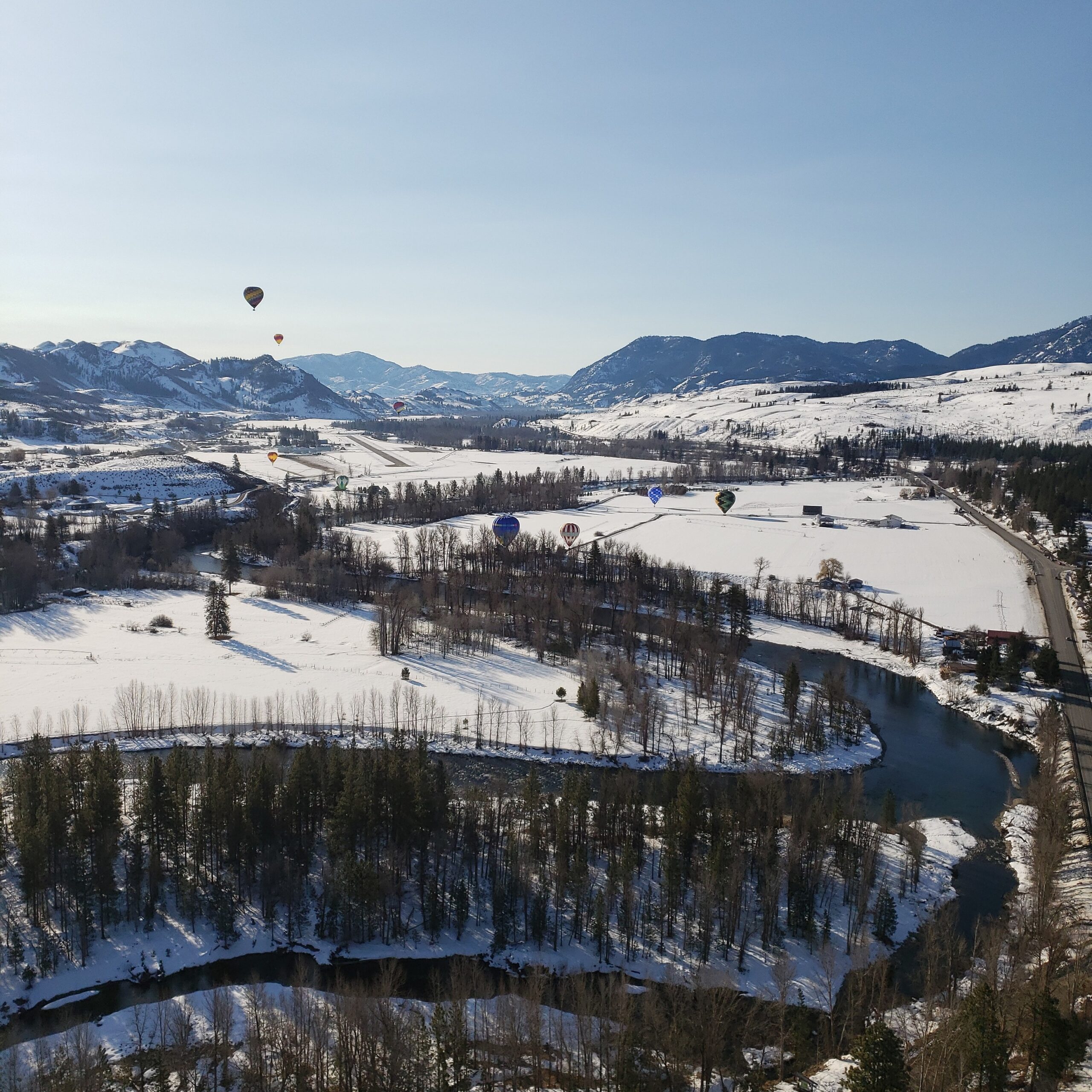 an arial view of a snow and tree covered landscape